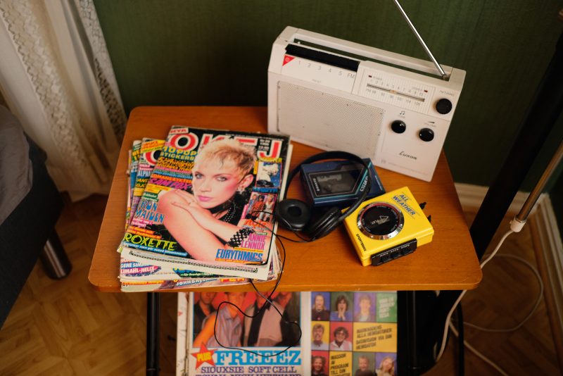Rekvisita ur Düsseldorf, Skåne. Ett nattygsbord med en radio, walkman och Okej-tidningar.