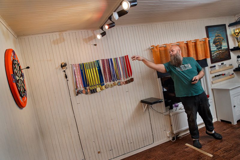 Dartkastaren Andreas "Dirty" Harrysson står i sin källare och tränar dart.