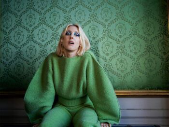 Veronica Maggio sitter på en bänk.